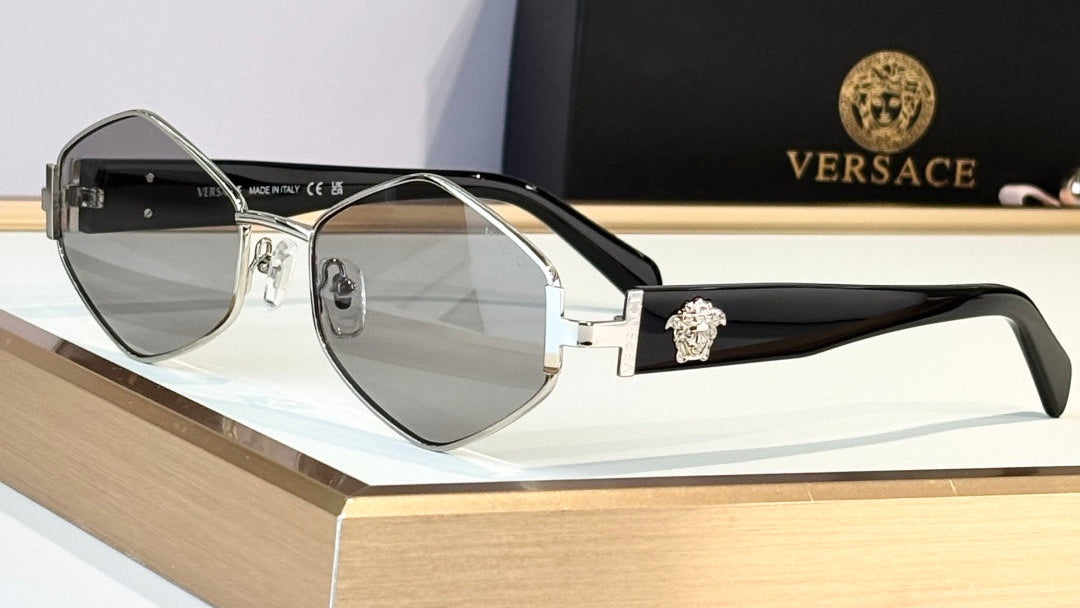 Versace sunglasses on a display stand with the brand's packaging in the background.